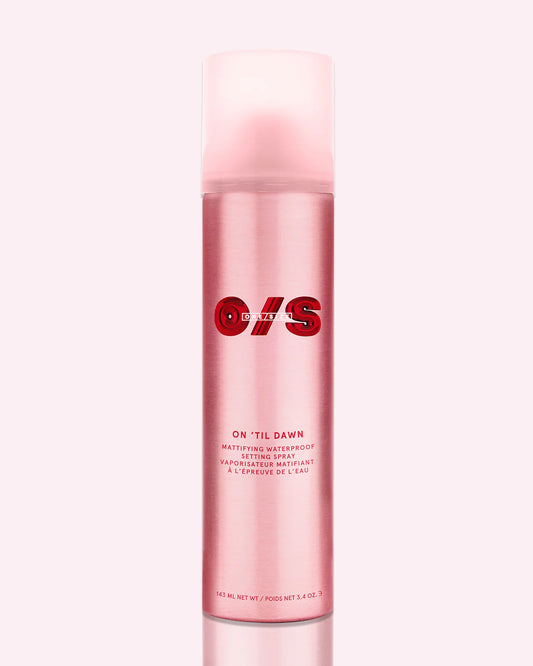 ONE/SIZE On ‘Til Dawn pink matte setting spray bottle with bold red branding, shown on glossy red background representing waterproof long-wear makeup lock and oil-control finish