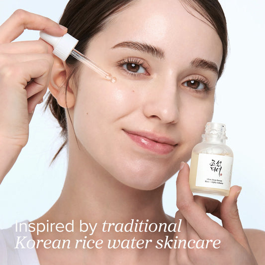 Model applying Beauty of Joseon Glow Deep Serum using dropper with visible glass skin glow on clean white background.