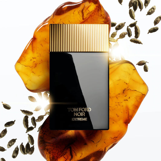 Tom Ford Noir Extreme EDP bottle styled with warm amber pieces and floating cardamom pods at ZARÉ Cosmetics